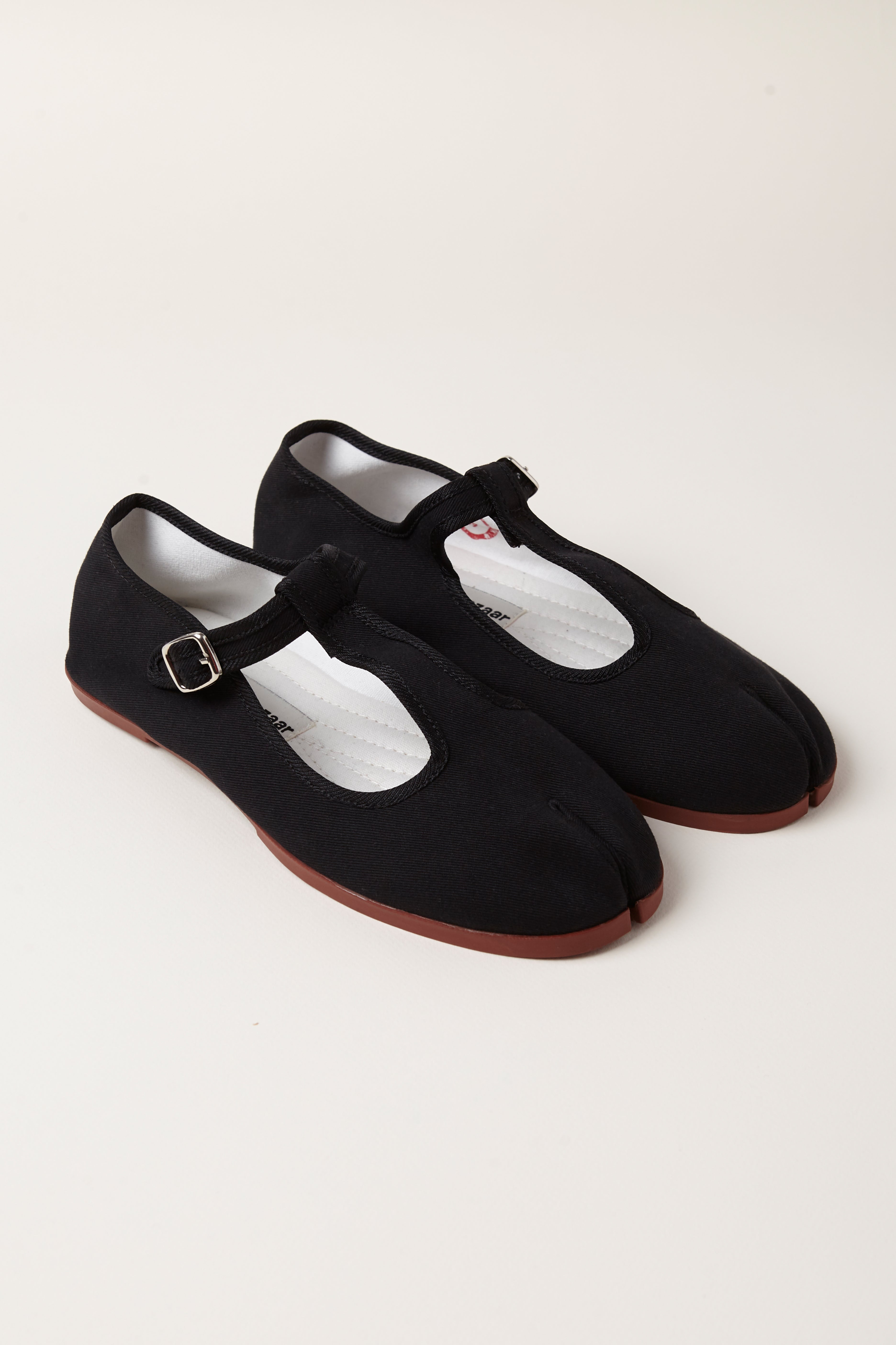 TRB#001, black tabi T-bar Mary Jane flats, three-quarter pair view on a pale background.